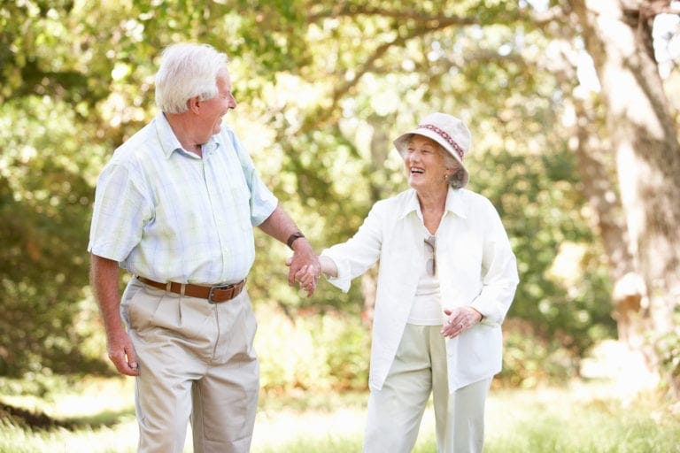 Happy seniors walking in park during Healthy Aging Month
