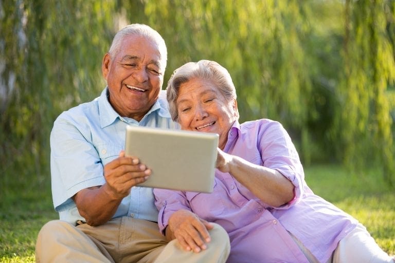 Couple using a tablet outside in the park