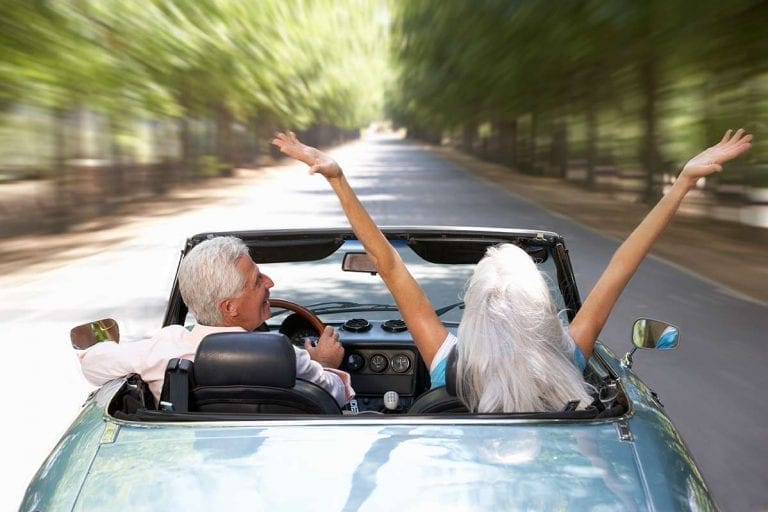 Elderly couple driving a convertible