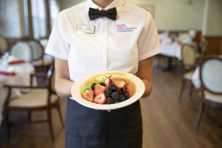 Server holding a plate of fruit