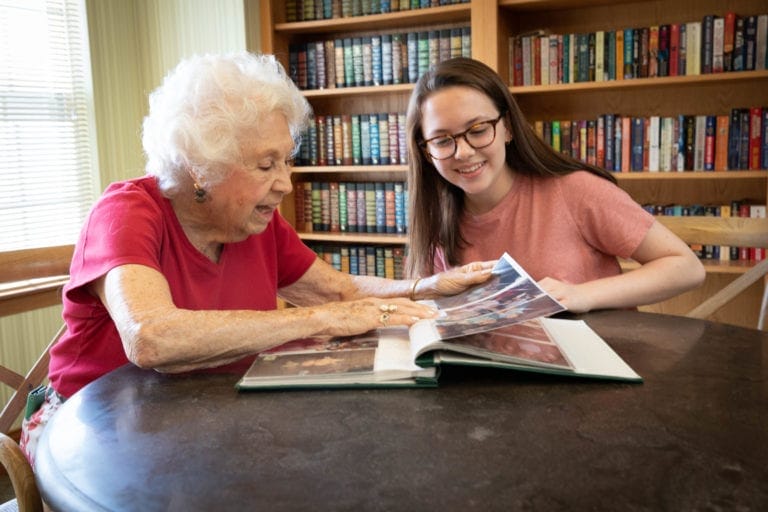 Elderly woman viewing photos with granddaughter