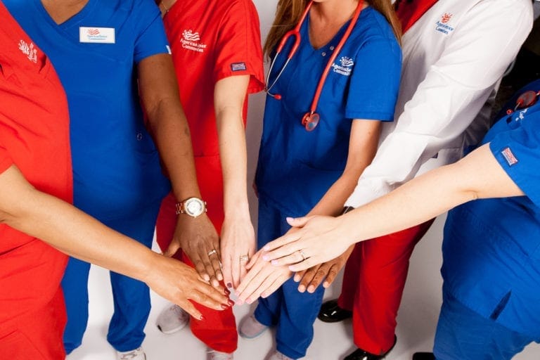 Group of employees with their hands in the center