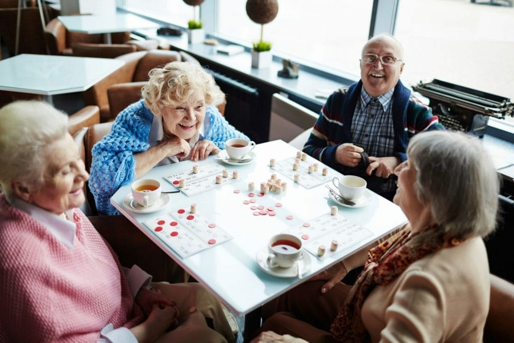 three elderly woman and one elderly man playing bingo