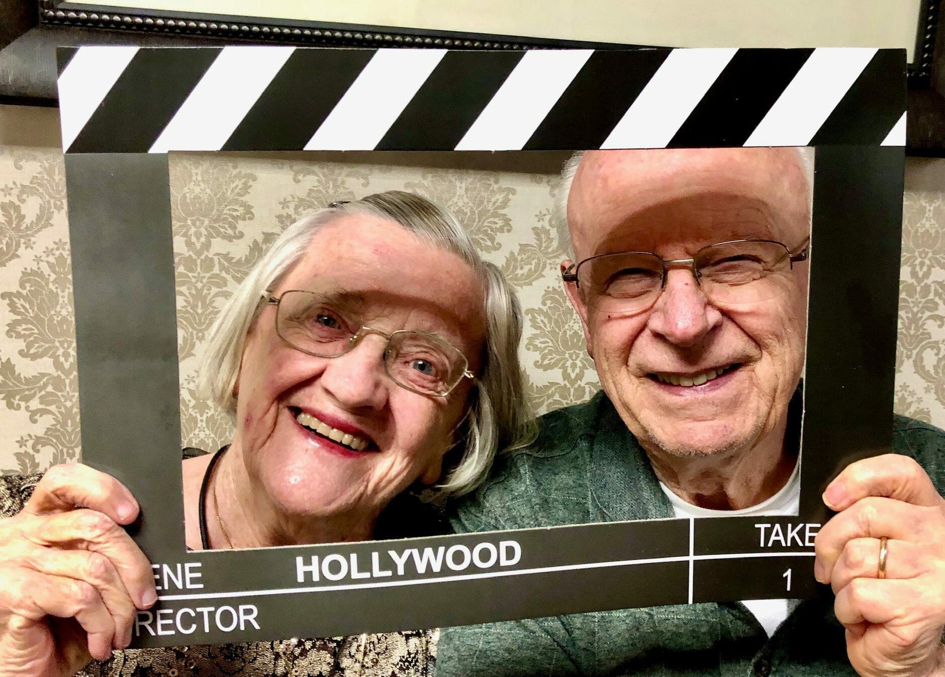 <span  class="uc_style_uc_tiles_grid_image_elementor_uc_items_attribute_title" style="color:#000000;">A happy senior couple holding a frame. </span>