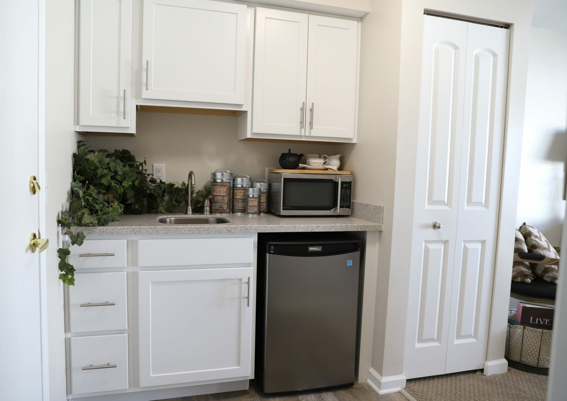 <span  class="uc_style_uc_tiles_grid_image_elementor_uc_items_attribute_title" style="color:#000000;">A kitchenette with a compact dishwasher, sink, and microwave. </span>