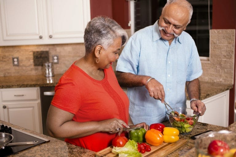 Senior Adult couple cooking together.