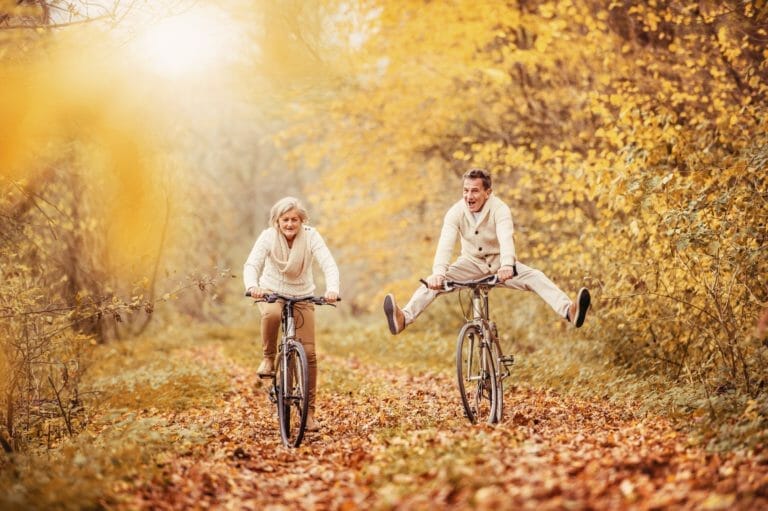 A senior man and woman riding bikes.
