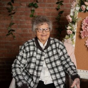 Centenarian Lois Smith with floral and brick background