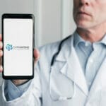 Doctor holding up phone showing CAREASCEND logo.